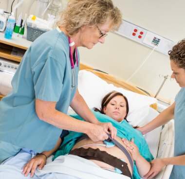 midwife and a doula helping a patient in labor