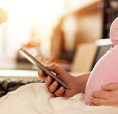 pregnant woman reading about contractions on her phone.